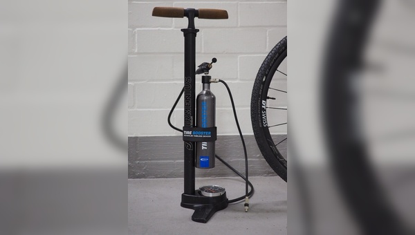 Eine Manschette hält Standpumpe und Tire Booster zusammen