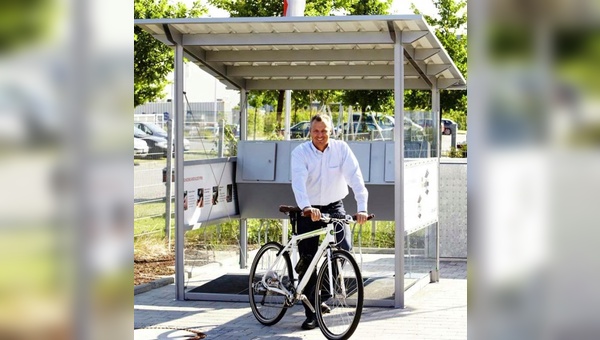 Spencer Hippe, Leiter des Geschäftsbereichs E‐Mobility, mit einem Pedelec der Marke Veelo vor dem Donauer Solar Bikeport.