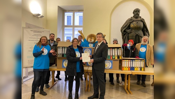 Radentscheid-Beauftragte Bernadette Felsch übergibt den Zulassungsantrag an Dr. Thum, den Leiter der Abteilung Wahlen im Bayerischen Innenministerium
