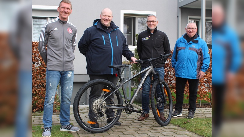 Vereinslegende Axel Bellinghausen, Gewinner Robert L., Joe Gerhards von Lucky Bike und der Vater des Gewinners bei der Übergabe des Rades.