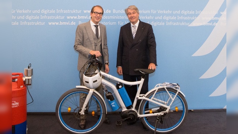 Verkehrsminister Dobrinth nimmt das Wasserstoff-Fahrrad aus den Händen von ...