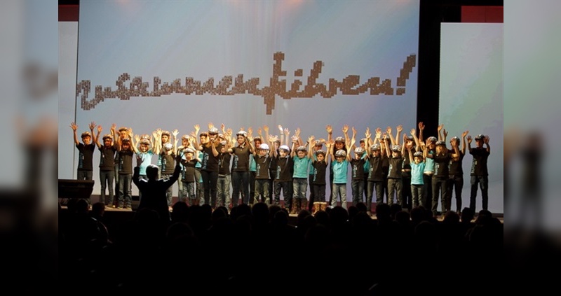 Auftritt eines Kinderchors im Rahmen der Jahresauftaktveranstaltung der Basler Gruppe Deutschland in Düsseldorf, bei dem alle Kinder einen der frisch gestifteten ABUS-Helme trugen.