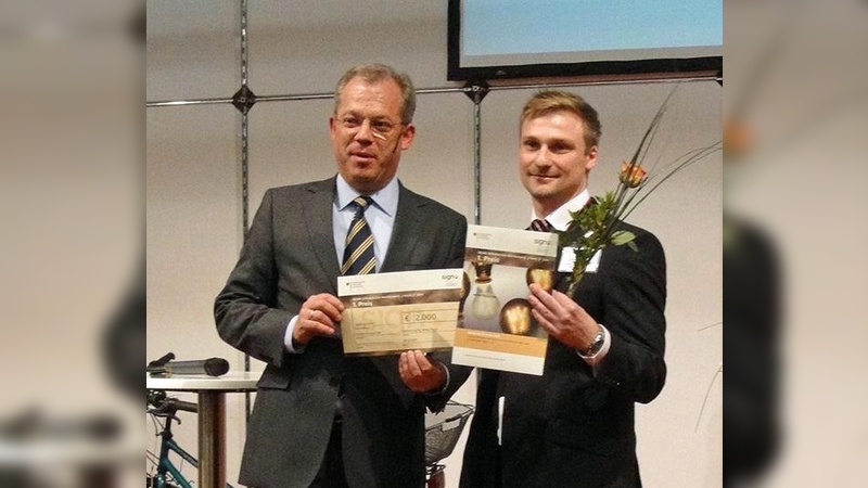 Adrian Floryszczak (r.) erhält den SIGNO Erfinderpreis von Ministrialrat Ulrich Dr. Romer