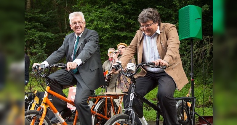 Winfried Kretschmann (vorne links) tritt kräftig in die Pedale, damit Bob Giddens (hinten mit Hut) und seine Band Gehör finden