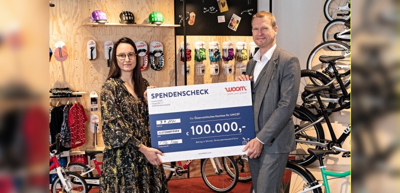 woom Projektmanagerin Marlene Fussi und Christoph Juenger, Geschäftsfuehrer des Oesterreichischen Komitees für UNICEF, bei der Uebergabe des Spendenschecks über 100.000 Euro.