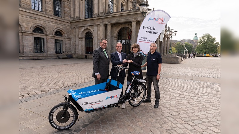 Patrick Döring (li.) und Georg Düsener (2.v.li.) übergeben das neue Lastenrad an Swantje Michaelsen und Ronald Brandt vom ADFC.